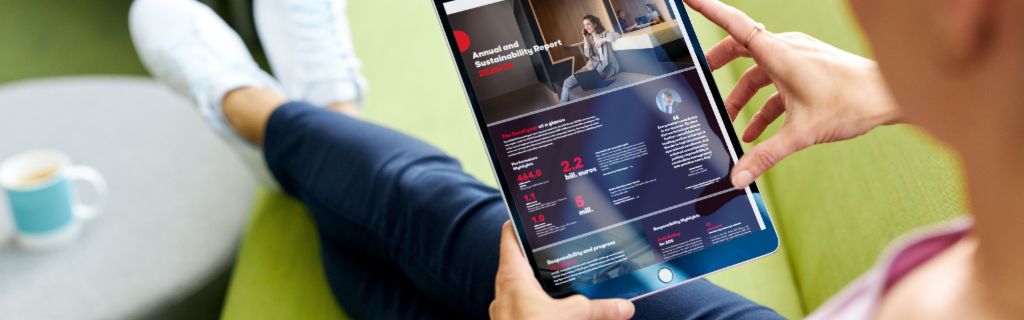 EOS ASR: Obrázek ukazuje mladou ženu, která drží tablet a prohlíží si na něm výroční zprávu o udržitelnosti společnosti EOS.