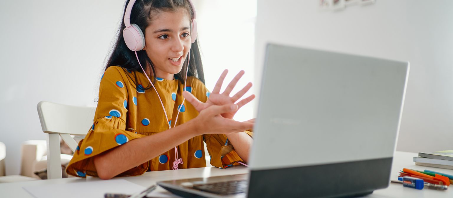 Financial literacy means responsibility: A girl sits at a laptop and takes part in online learning. 