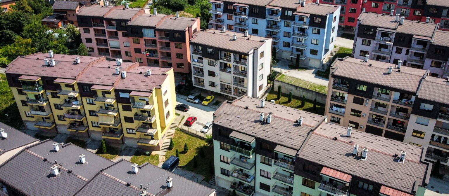 NPL zajištěné nemovitostmi: letecký pohled na živý rezidenční komplex s vícebarevnými bytovými domy obklopenými zelenými plochami v Bosně a Hercegovině
