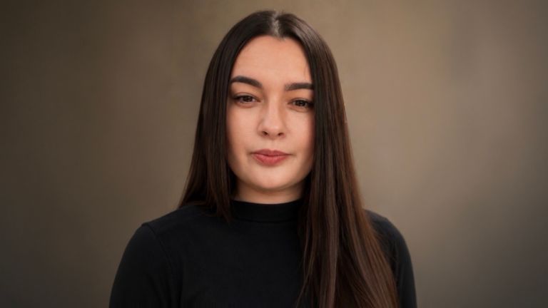 Daniela Moaca, Senior Manager IT ve společnosti EOS Romania, portrétní fotografie v tmavém rolákovém svetru.