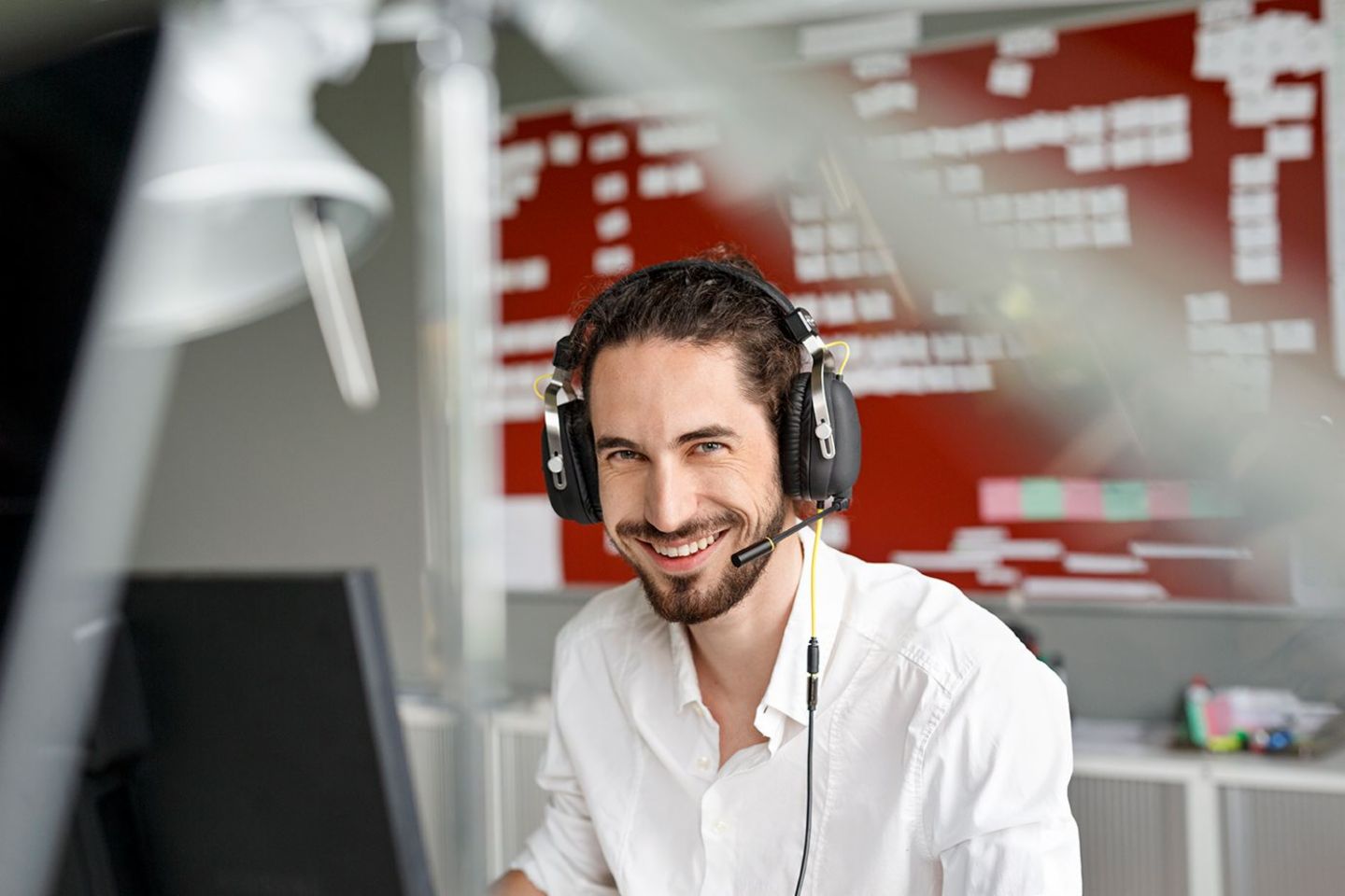 Artificial intelligence in the call center. Call center agent smiling at his workstation.