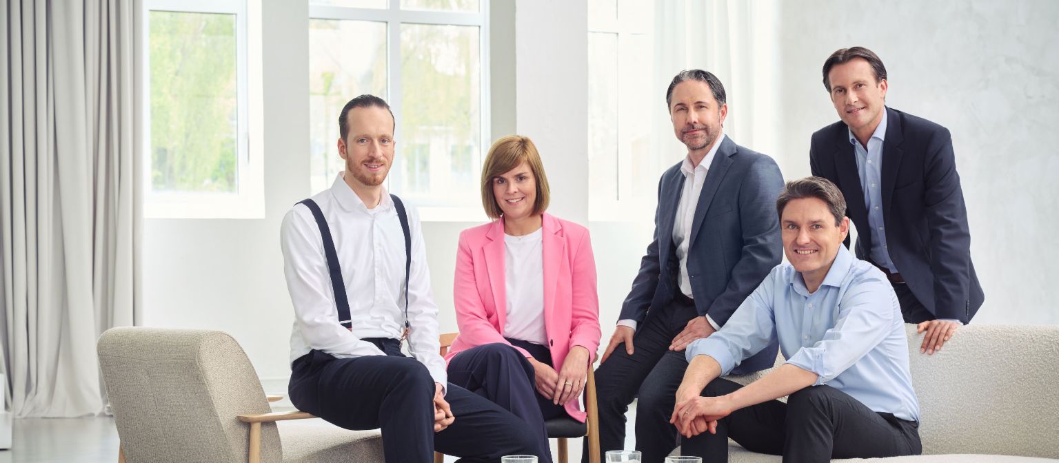 Představenstvo skupiny EOS (zleva doprava: Sebastian Pollmer, Dr. Eva Griewel, Marwin Ramcke, Dr. Stephan Ohlmeyer, Carsten Tidow), v jasné místnosti, dívající se přímo do kamery