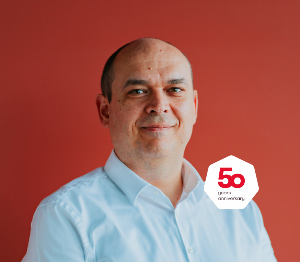 Portrét Cristiana Musata, generálního ředitele EOS Technology Solutions před červeným pozadím