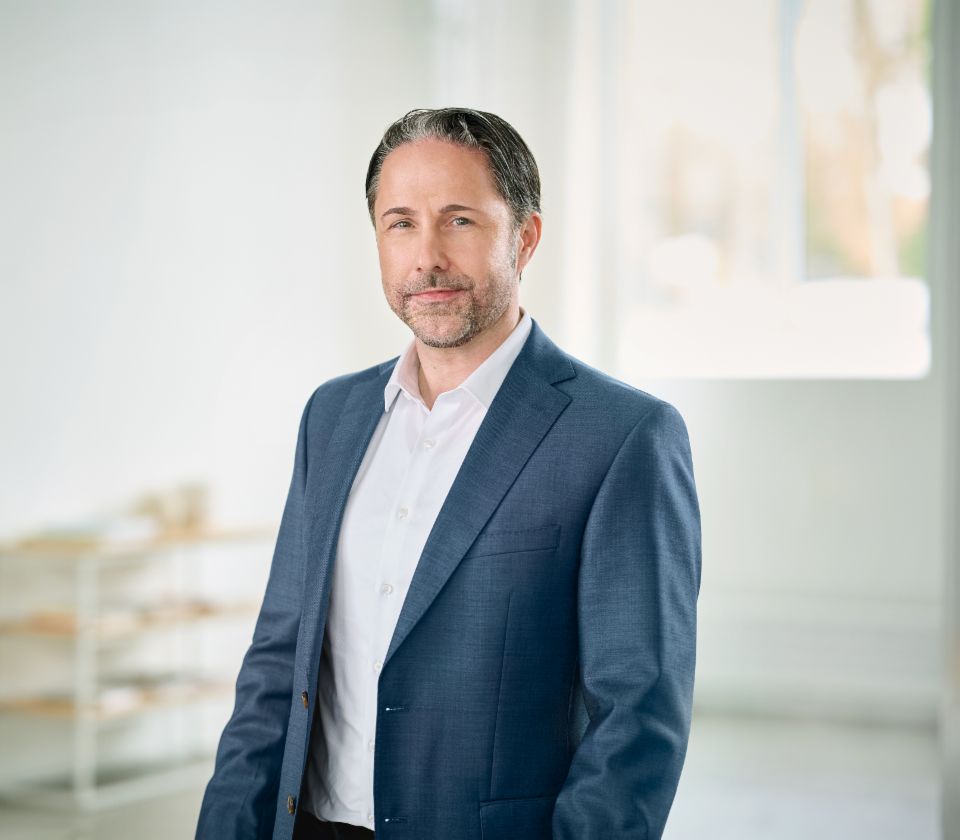 Portræt af Marwin Ramcke, formand for bestyrelsen i EOS Group, i et lyst rum iført en mørk blazer