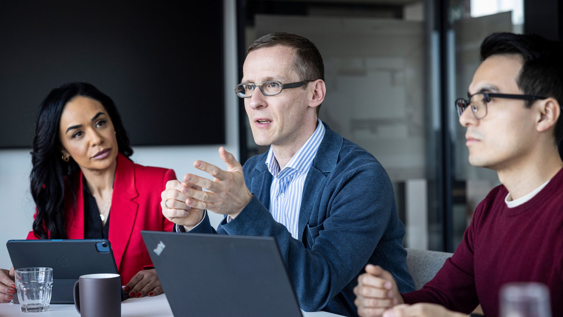 Tři lidé vedou rozhovor v kanceláři.